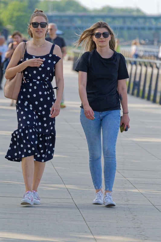 Two young women walking down an alley